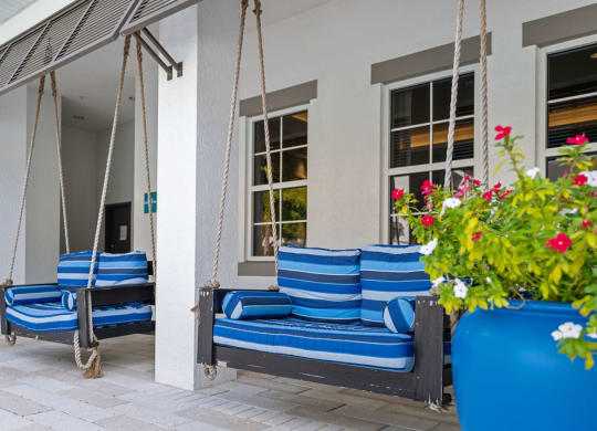 two love seat size swings with blue cushions outside the clubhouse at Inspira, Naples, FL