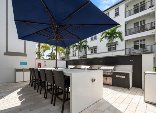 a kitchen with a bar and chairs under an umbrella at Inspira, Florida, 34113