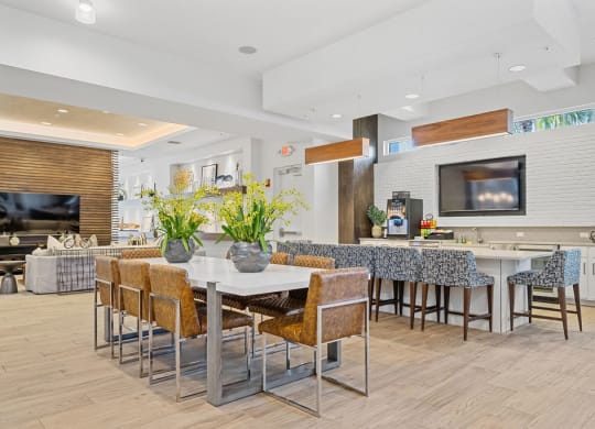 a dining area with a table and chairs and a kitchen with a television at Inspira, Naples, Florida