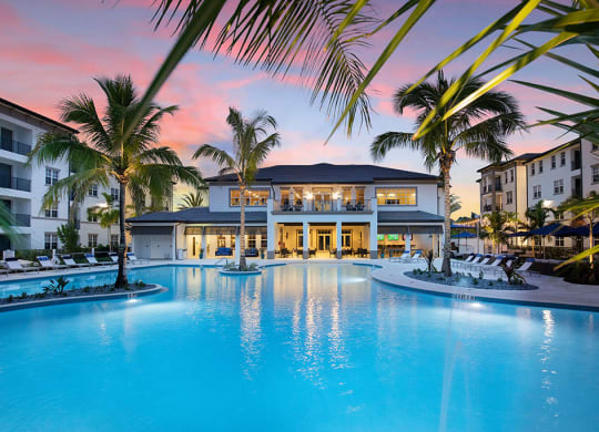 a large swimming pool in front of a resort with palm trees at Inspira, Florida