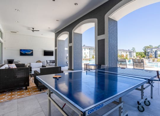 a ping pong table on a patio with a pool