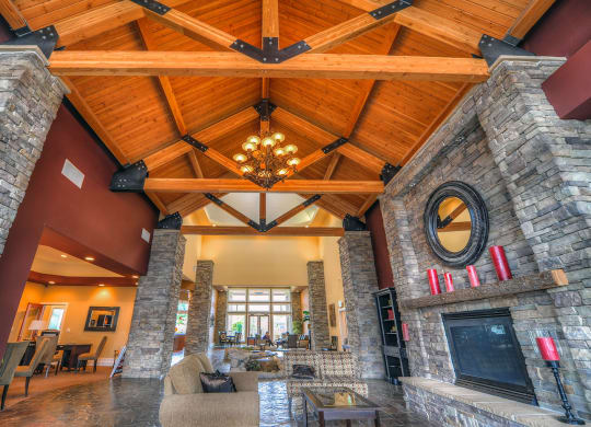 a large living room with a vaulted wood ceiling and stone walls at Madison Sierra Sun, Puyallup, WA