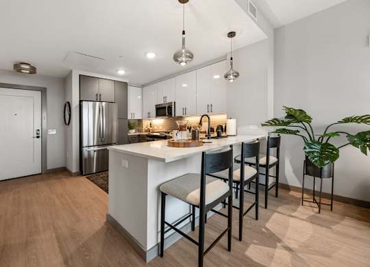 an open kitchen with a large island with bar stools