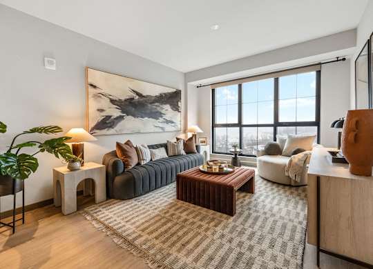 a living room with a couch and a coffee table in front of a window