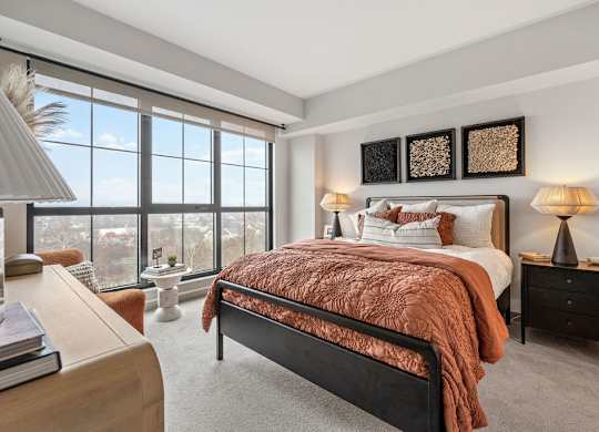 a bedroom with a bed and a large window