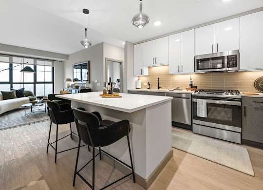 an open kitchen and living room with a white counter top