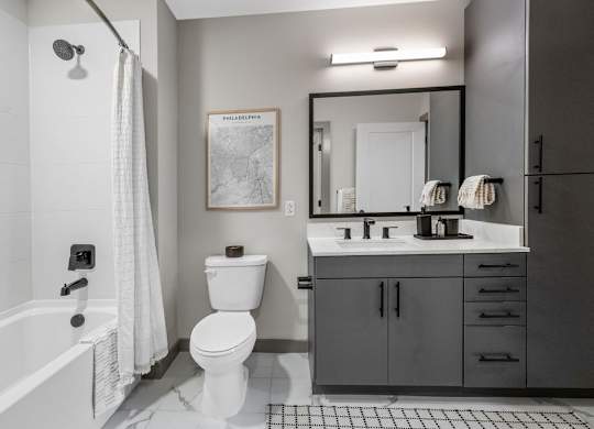 a bathroom with a toilet sink and shower and a mirror