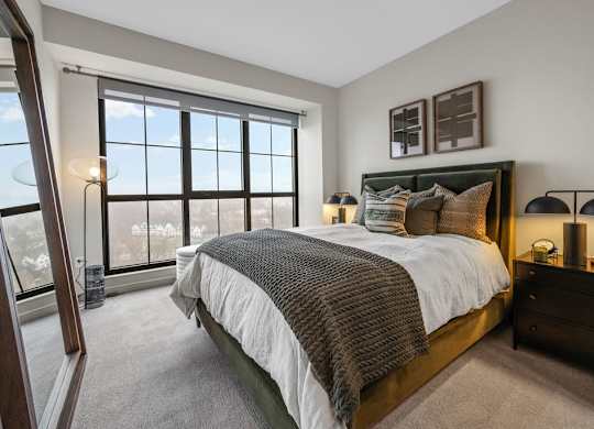 a bedroom with a large window and a bed
