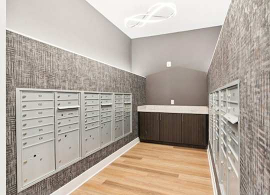 A hallway with a row of mailboxes on the wall.