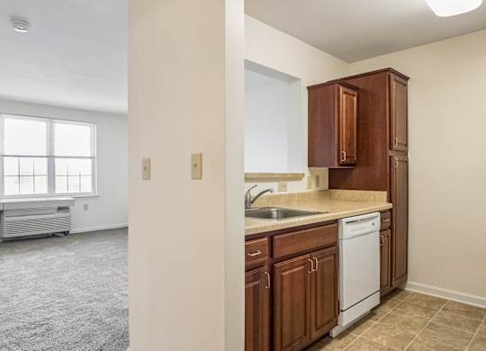 A kitchen with brown cabinets and a white dishwasher.
