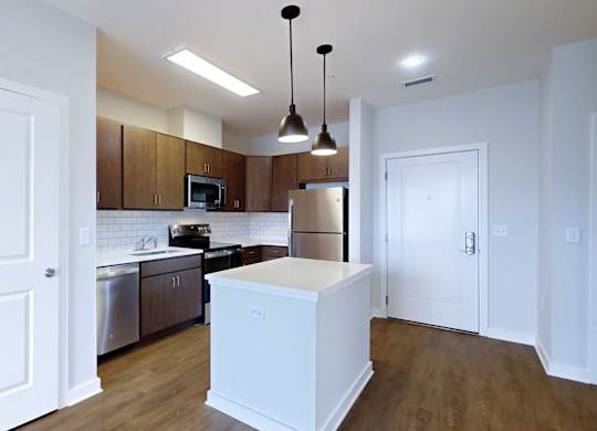 A kitchen with white cabinets and a white island.