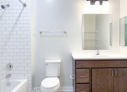 A white toilet sits next to a white sink in a bathroom.