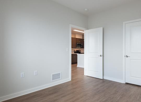 A room with two doors and a hallway leading to another room.