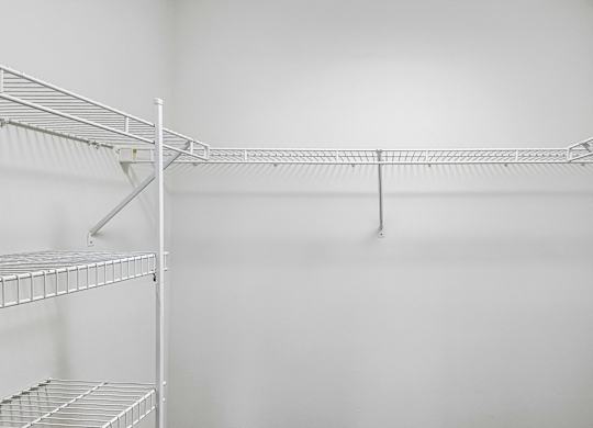 Empty shelves in a white pantry.