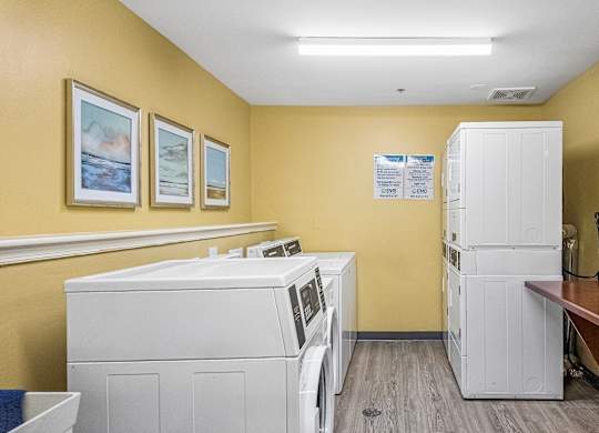 A laundry room with washing machines and a dryer.