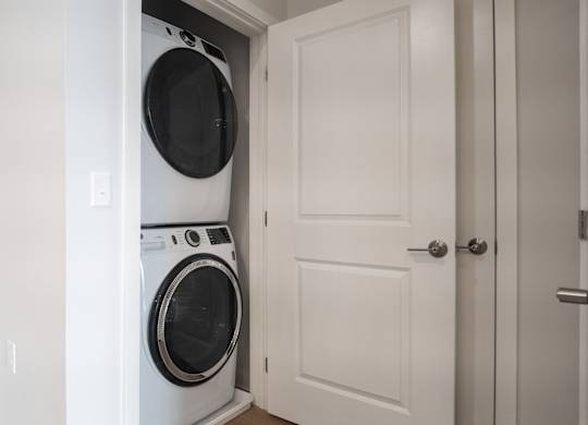 A white washing machine is in a white doorway.