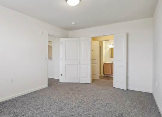 A room with white walls and a grey carpet.