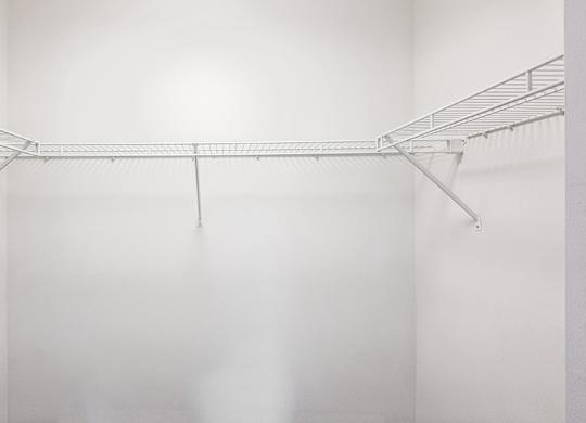 A white wall with a metal rack on it.