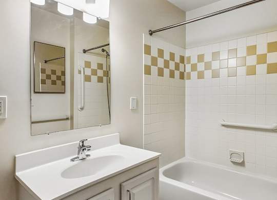 A bathroom with a white sink and a white bathtub.