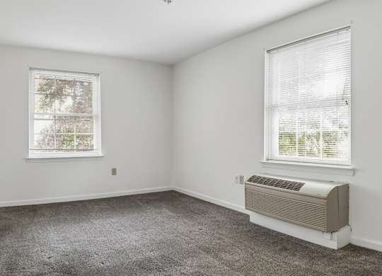 A room with a window and a wall-mounted air conditioner.