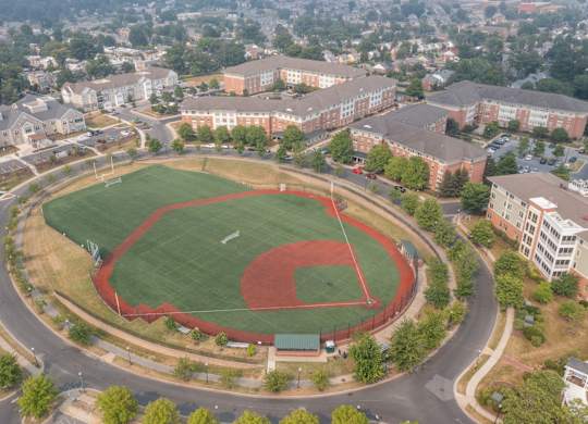 an aerial view of a baseball field with buildings in the background