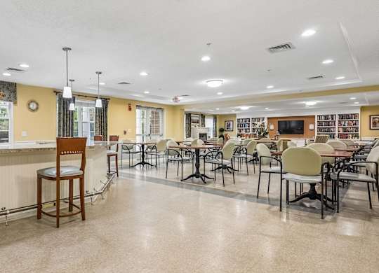 A room with tables and chairs is empty.