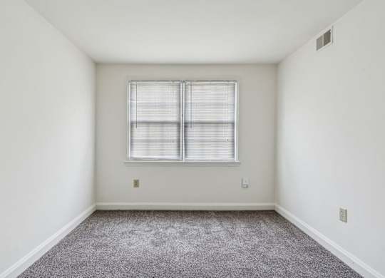 Carpeted bedroom in Park View at Towson with two windows and closet space
