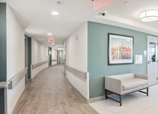 A hallway with a bench and a framed picture on the wall.