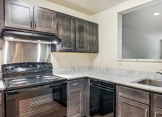 A kitchen with a stove, oven, and sink.
