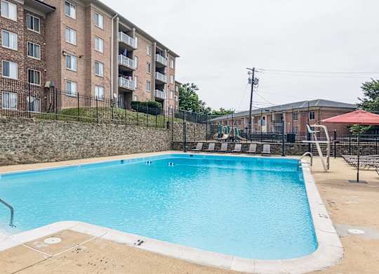 A swimming pool in front of apartment buildings.