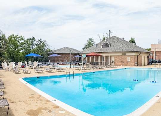 A large outdoor swimming pool with a building in the background.