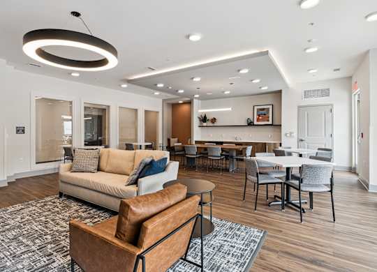 A modern living room with a brown leather sofa and a grey rug.