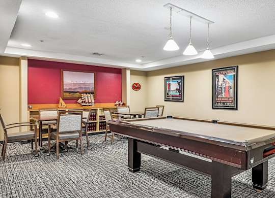 A room with a pool table and a dining table.