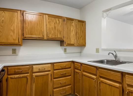 A kitchen with wooden cabinets and a white countertop.