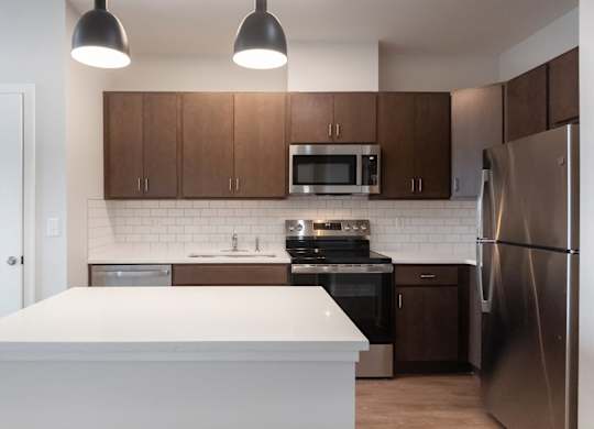 A kitchen with a white island in the middle of it.