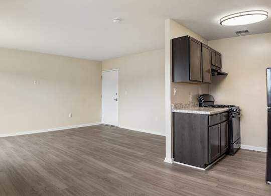 A kitchen area with a refrigerator, microwave, and cabinets.