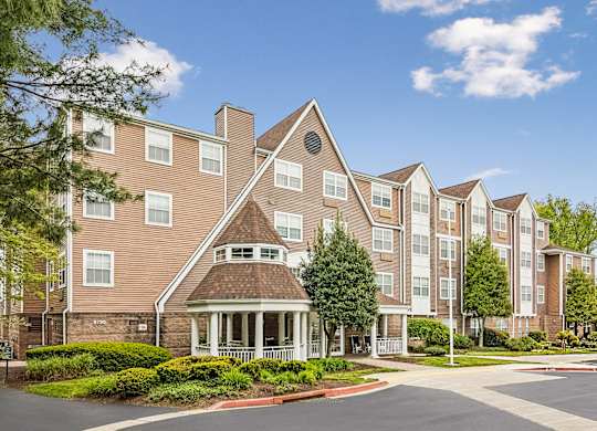 A large apartment complex with a central courtyard and a variety of trees.