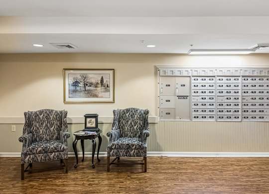 A waiting room with chairs and a painting on the wall.