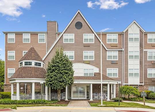A large apartment complex with a gazebo-like structure in the front.