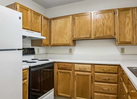 A kitchen with wooden cabinets and a white refrigerator.