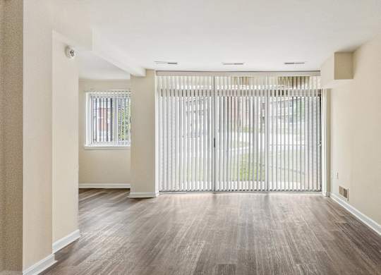 A room with a sliding door and wooden flooring.
