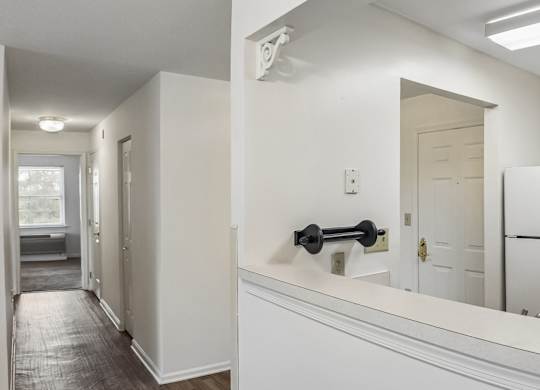 A white kitchen with a black handle on the counter.