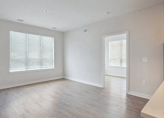 A spacious room with a window and a door.