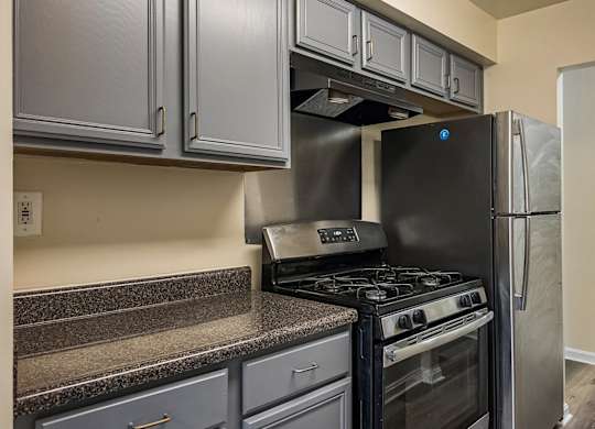 A kitchen with a black stove and refrigerator.