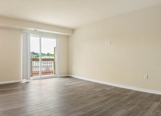 A room with a sliding glass door leading to a balcony.