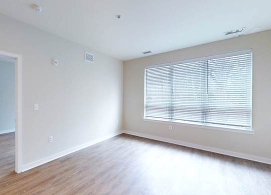 A room with a door and a window with blinds.