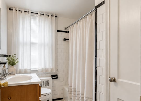 A white bathroom with a black and white tiled floor.