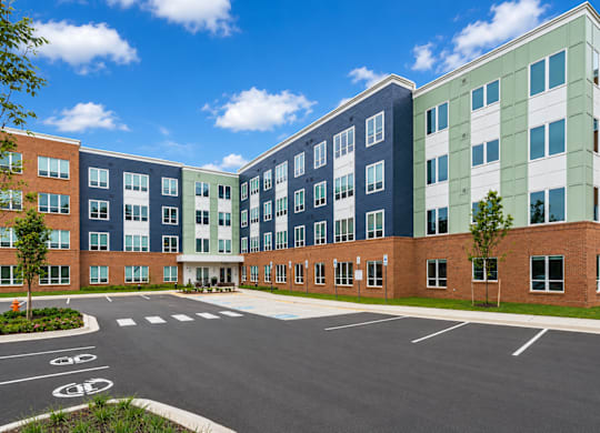 A multi-story building with a parking lot in front.