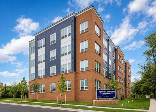 A multi-story building with a blue sign in front.