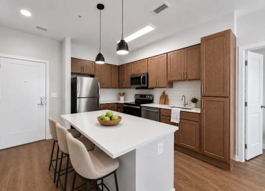 A kitchen with a white countertop and wooden cabinets.